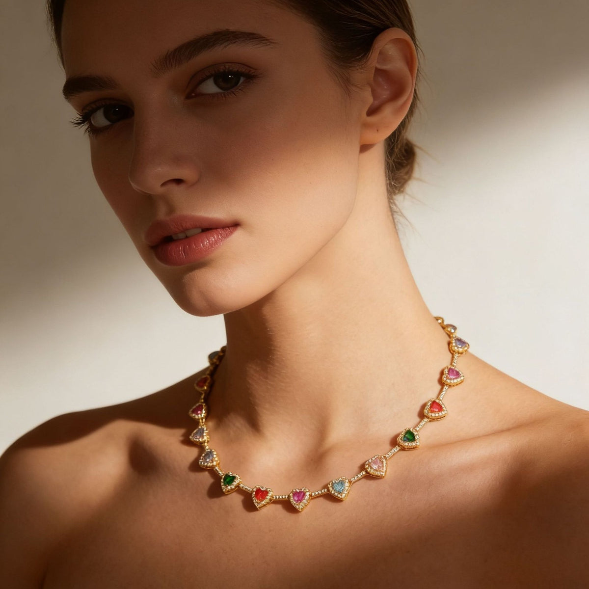 Model wearing the Rainbow Heart Necklace in gold